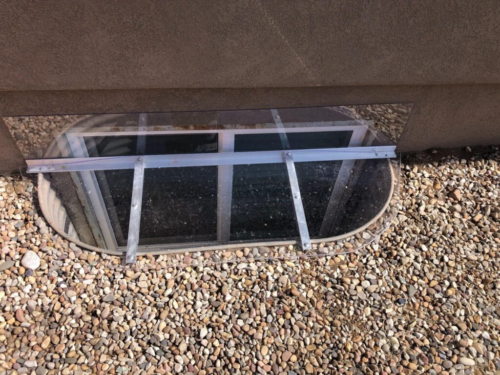 A wall featuring a large window with a smaller window set within it allowing light to enter the space