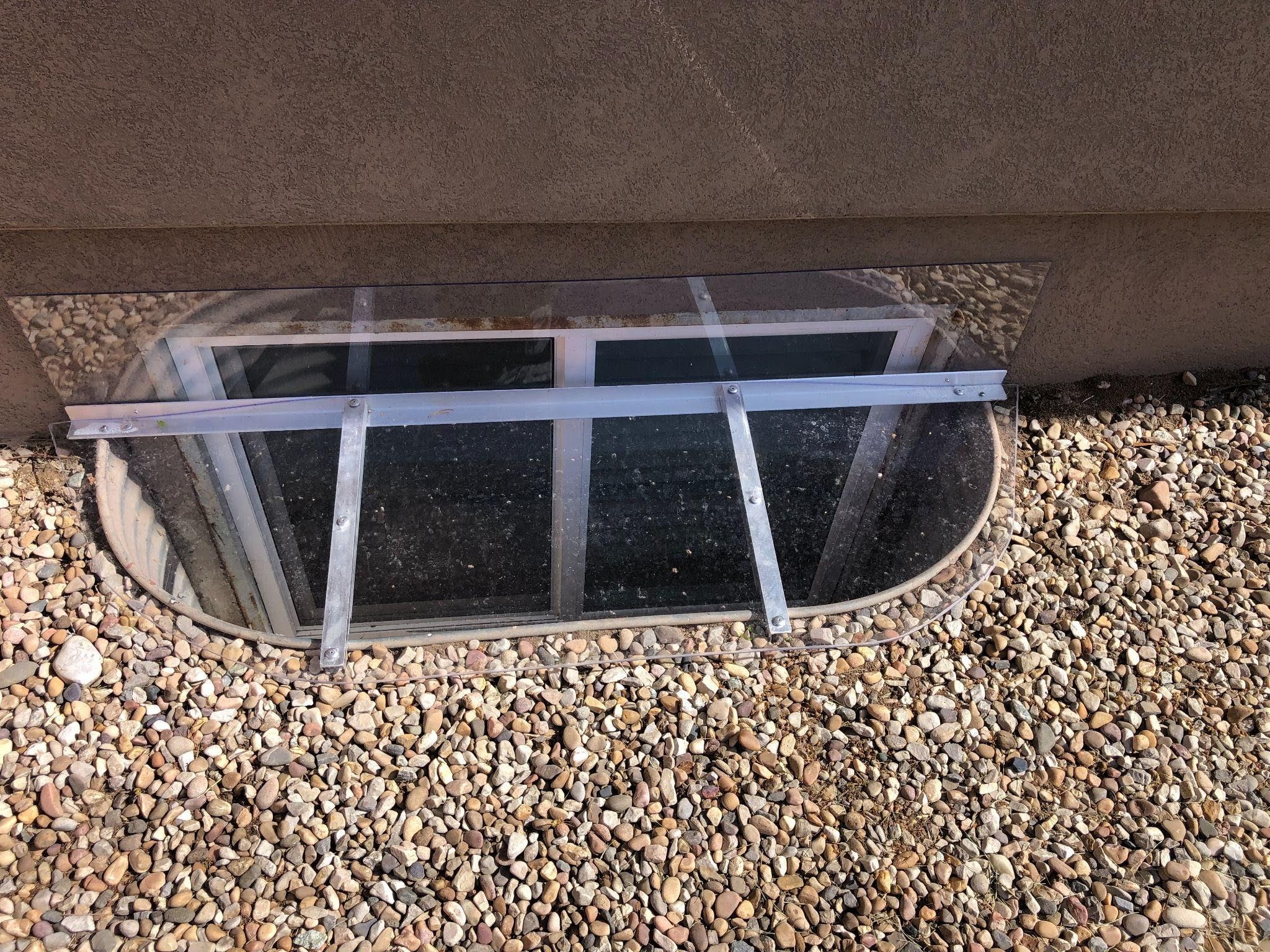 A wall featuring a large window with a smaller window set within it allowing light to enter the space