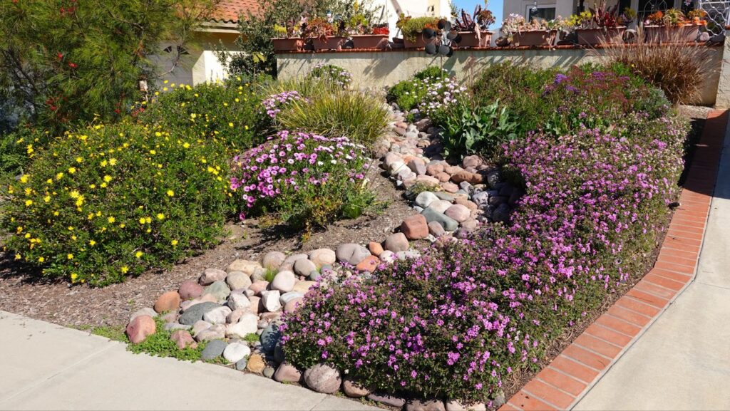 A beautiful flower garden with rocks and plants, perfect for landscaping around your window well