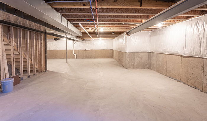 A basement with concrete flooring and walls, ideal for insulating to create an energy-efficient home