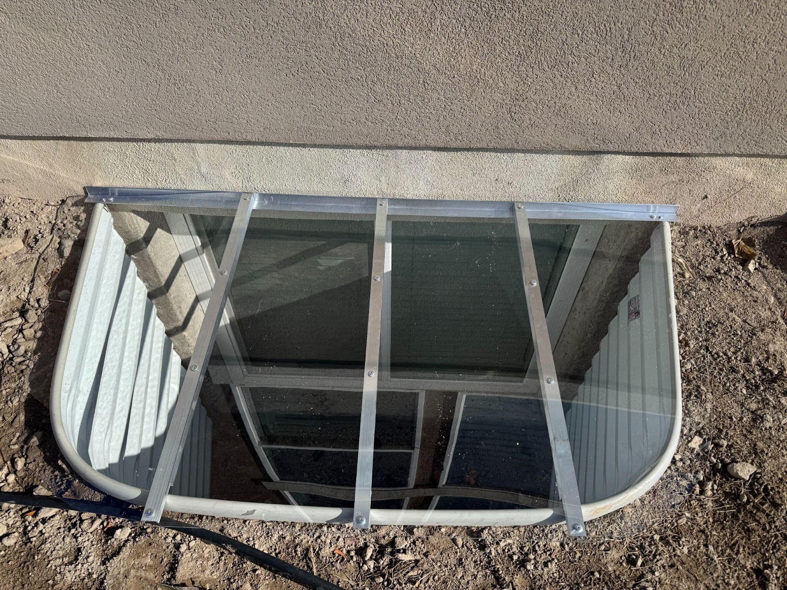 A house window featuring a sturdy metal frame allowing natural light to enter the interior space
